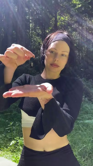 Woman applying sacred oil outdoors in sunlight, promoting natural wellness and mindful living