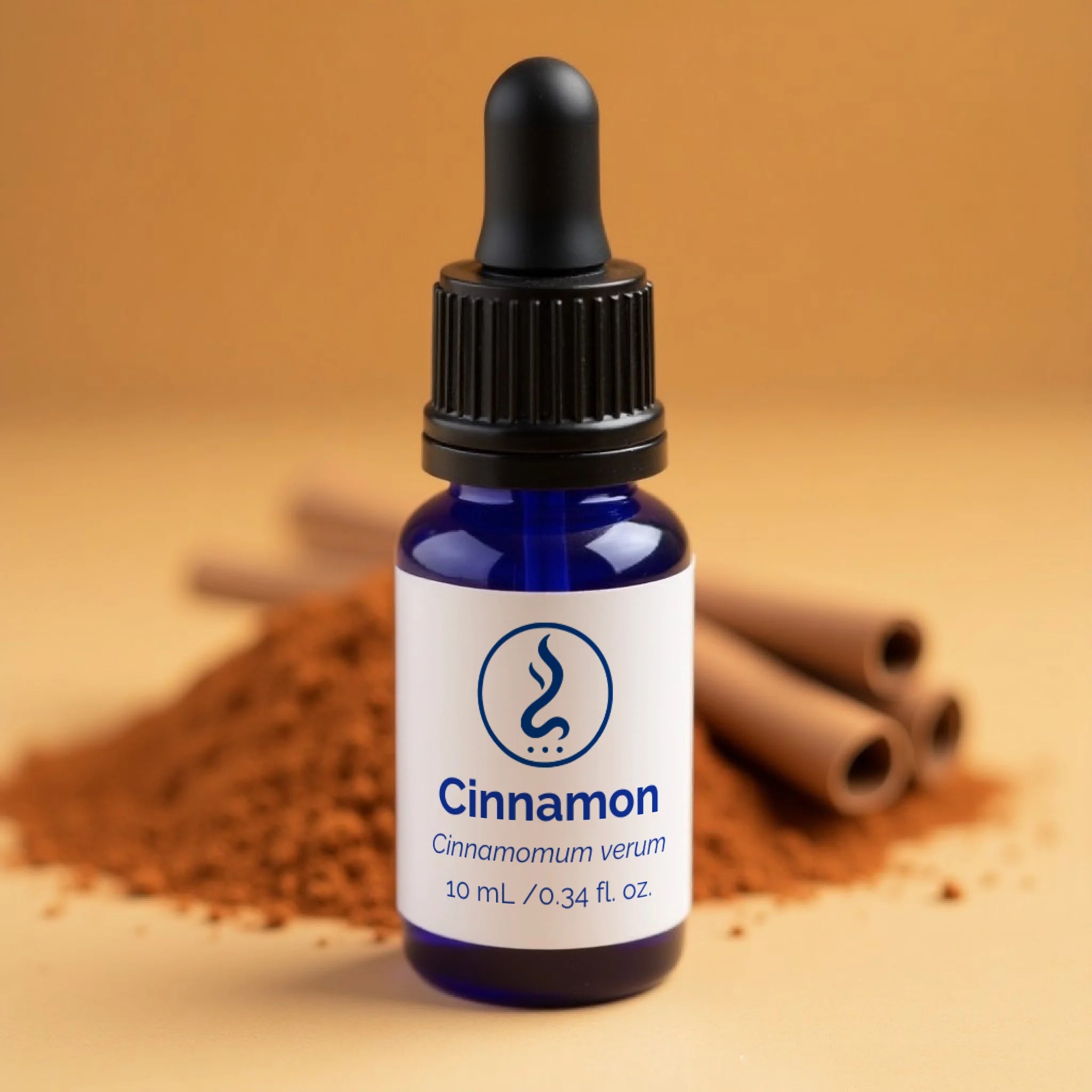 Blue dropper bottle of Sahu Sacred Oils Cinnamon essential oil with cinnamon sticks and powder.
