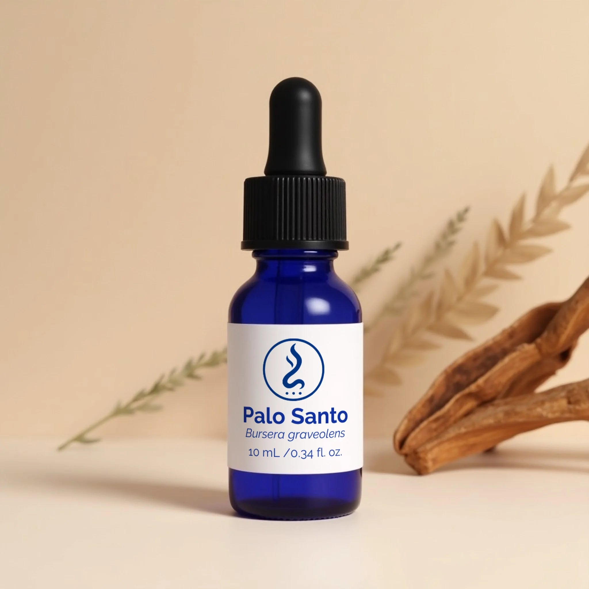 Blue dropper bottle of Sahu Sacred Oils Palo Santo oil with wooden sticks and leaves.