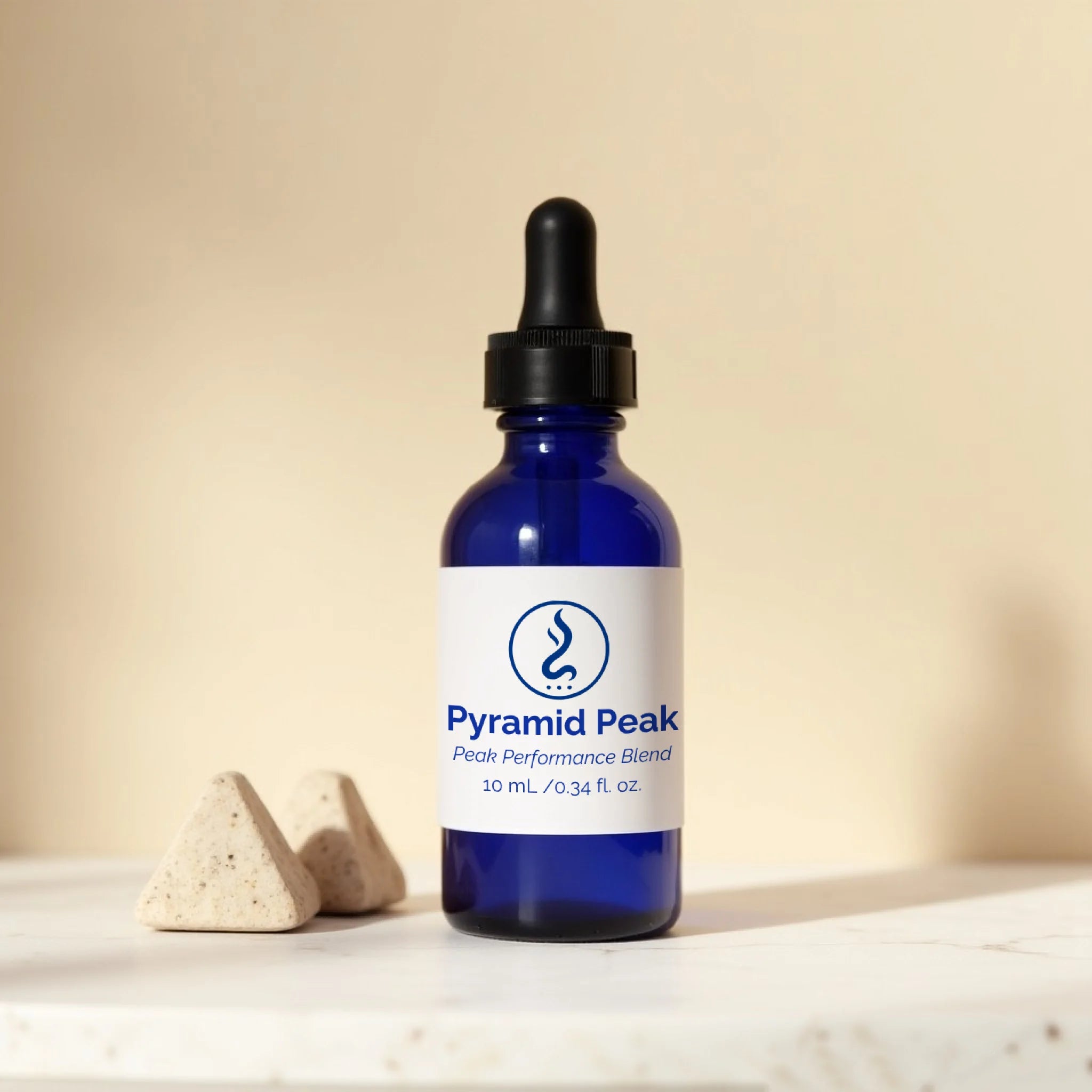 Blue bottle with a dropper labeled 'Pyramid Peak' on a beige background